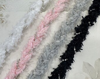 May include: Four different types of trim with a fuzzy texture and silver glitter accents. The trims are white, pink, gray, and black.
