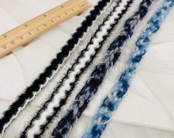 Puede incluir: Cinco tipos diferentes de ribete con texturas peludas en negro, blanco, azul y gris. El ribete se coloca sobre una superficie blanca con una regla para la escala.