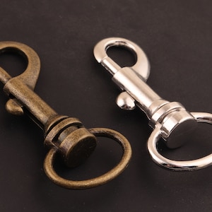 May include: Two metal keychains, one silver and one antique gold, with a swivel clasp and a ring.