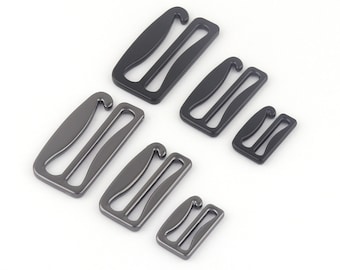 May include: Five metal bra strap extenders in different sizes. The extenders are black and silver in color.