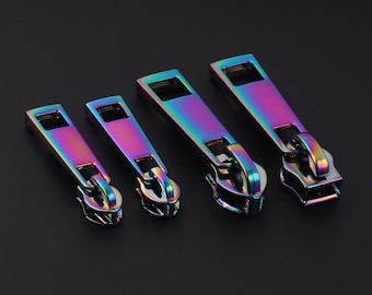 May include: Four iridescent zipper pulls in different sizes. The pulls are made of metal and have a rainbow finish.