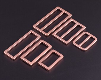 Puede incluir: Un juego de seis hebillas deslizantes de metal de color oro rosa en varios tamaños. Las hebillas son rectangulares y tienen un acabado liso.