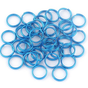 May include: A pile of bright blue metal key rings. The rings are all the same size and are arranged in a random pattern.