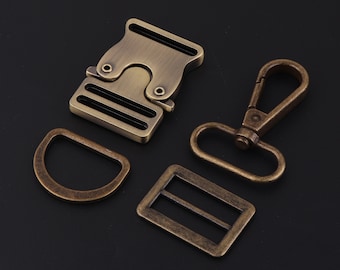 May include: Four antique gold-toned metal hardware pieces: a buckle, a D-ring, a slider, and a trigger snap hook.