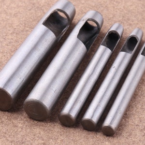 May include: Set of six silver metal leather hole punch tools with different sizes. The tools are marked with numbers 1, 2, 3, 4, 5, and 6.