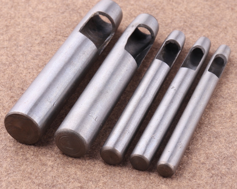May include: Set of six silver metal leather hole punch tools with different sizes. The tools are marked with numbers 1, 2, 3, 4, 5, and 6.