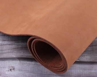 May include: A close-up of a rolled piece of brown leather. The leather is soft and supple, with a natural grain.