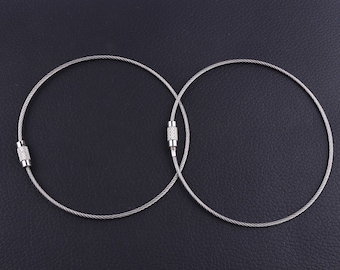 Puede incluir: Dos llaveros de metal plateado con un diseño de cable trenzado y tapas de extremo plateadas.