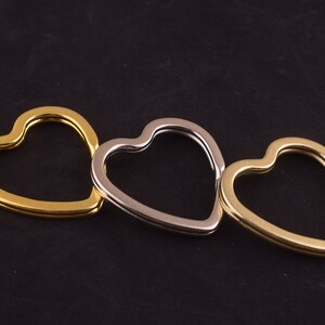 May include: Three heart-shaped keyrings in gold, silver and brass.