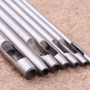 May include: Set of six silver metal leather hole punches of varying sizes.