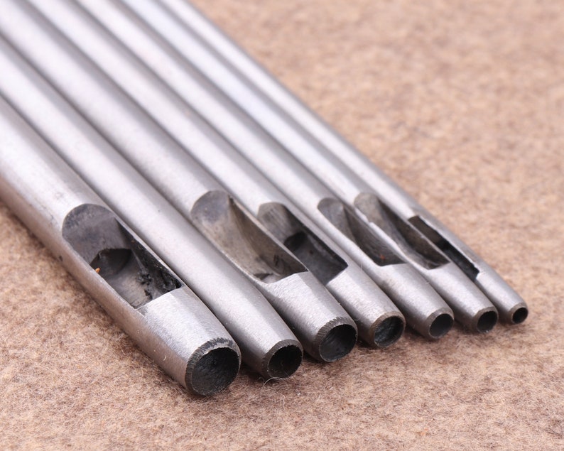 May include: Set of six silver metal leather hole punches of varying sizes.