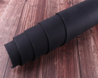 May include: A roll of black leather, rolled up and displayed on a wooden surface.