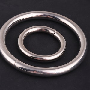 May include: Two silver metal rings, one larger than the other, are nested together. The rings are smooth and shiny.