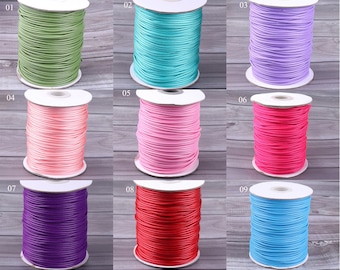 May include: Nine spools of waxed cotton cord in various colors, including green, turquoise, lavender, pink, red, light blue, purple, and dark blue. The spools are arranged in three rows of three.
