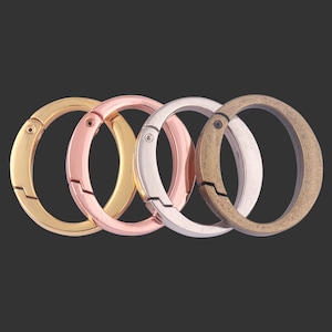 May include: Four key rings in different colors: gold, silver, rose gold, and bronze. Each ring has a spring-loaded opening mechanism.