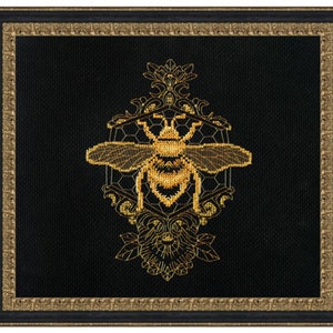 May include: A gold bee embroidered on black fabric with a honeycomb and floral design. The bee is surrounded by a gold ornate frame.