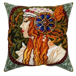 May include: A decorative pillow with a needlepoint design of a woman with long red hair wearing a floral headband. The background is a green and brown floral pattern.