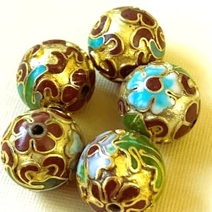May include: Six round, decorative beads with a gold-colored base and intricate floral designs. The beads feature a combination of maroon, turquoise, and green enamel, creating a vibrant and detailed appearance. These beads are suitable for jewelry making or craft projects.