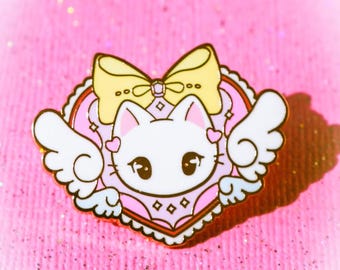 May include: A white cat with pink wings and a yellow bow is inside a pink heart with a white lace border. The cat is wearing a pink and white dress with a white diamond pattern. The heart is on a pink sparkly background.