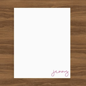 Peut inclure: Une feuille de papier blanche avec le nom "jenny" écrit en cursive rose en bas.