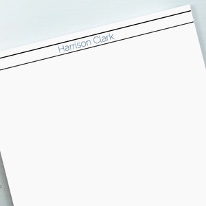 Może przedstawiać: Biała kartka papieru z czarną linią u góry i nadrukowanym niebieskim tekstem "Harrison Clark".