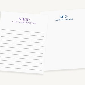 May include: Two white lined notepads with personalized monograms. The top notepad has the monogram "N|H|P" and the text "NANCY HELENA PONDER". The bottom notepad has the monogram "M|G" and the text "MICHAEL GROVES".