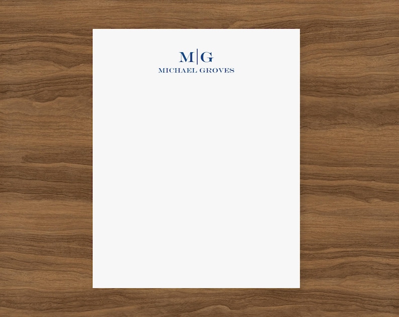 May include: White stationery with a blue monogram of the letters "M" and "G" in a square. The text "MICHAEL GROVES" is below the monogram.