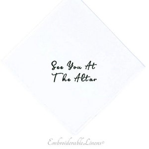 May include: White linen handkerchief with black embroidery that reads "See You At The Altar".