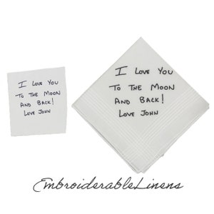 K&ouml;nnte beinhalten: Ein wei&szlig;es quadratisches Taschentuch mit schwarzer Stickerei, die I Love You To The Moon And Back! Love John lautet, neben einem quadratischen Papiernotizzettel mit derselben handschriftlichen Nachricht in schwarzer Tinte auf wei&szlig;em Grund.