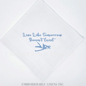 K&ouml;nnte beinhalten: Ein quadratisches wei&szlig;es Taschentuch mit hellblauer Stickerei. Der Text "Live Like Tomorrow Doesn't Exist" ist in Schreibschrift &uuml;ber einer stilisierten hellblauen Signatur gestickt. Der Stoff hat ein dezentes gestreiftes Randmuster.