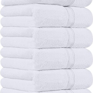 May include: A stack of eight white bath towels. Each towel is folded and has a textured surface. The towels are neatly arranged, with the folded edges aligned, creating a clean and organized appearance. The towels are a solid white color.