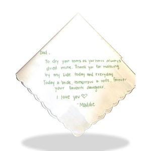 K&ouml;nnte beinhalten: Ein wei&szlig;es quadratisches Taschentuch mit gewelltem Rand und gr&uuml;ner Stickerei mit dem Text: Dad, To dry your tears as you have always dried mine. Thank you for walking by my side today and everyday. Today a bride, tomorrow a wife, forever your favorite daughter. I love you -Maddie.
