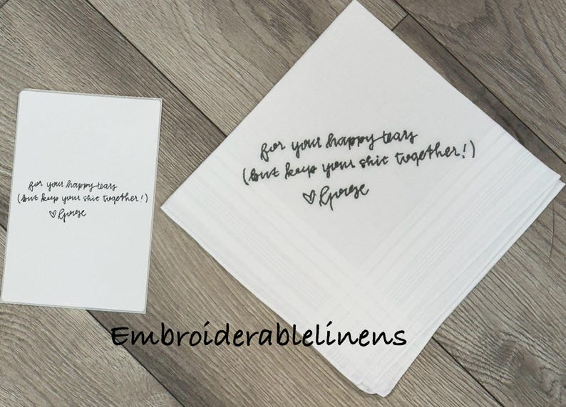 K&ouml;nnte beinhalten: Ein wei&szlig;es quadratisches Taschentuch und eine passende rechteckige Karte, beide mit schwarzem kursivem Text: for your happy tears (but keep your shit together!) mit einem Herzsymbol und dem Namen George unter dem Text.
