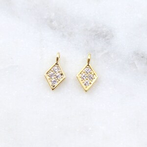 May include: Two gold diamond-shaped charms with clear cubic zirconia stones.