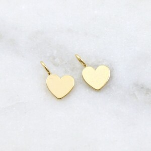 May include: Two gold heart-shaped charms with a loop at the top for attaching to jewelry.