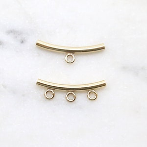 Puede incluir: Dos tapas de cuentas de metal dorado con bucles. La tapa superior tiene un bucle, y la tapa inferior tiene tres bucles.