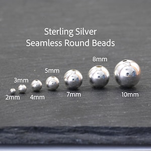 May include: Sterling Silver Seamless Round Beads in various sizes ranging from 2mm to 10mm. The image displays seven polished, spherical silver beads arranged in a row, each labeled with its specific diameter in millimeters.