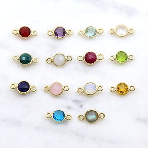 Peut inclure: Assortiment de 12 breloques connecteurs plaqués or avec différentes couleurs de pierres précieuses, notamment rouge, violet, vert, bleu, blanc et jaune. Chaque breloque présente une pierre précieuse ronde avec une boucle plaquée or de chaque côté.