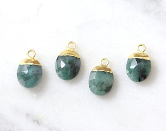 May include: Four emerald green gemstone pendants with gold accents. Each pendant has a gold bail for attaching to a necklace or bracelet.
