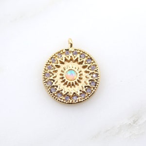 May include: Gold pendant charm with a round, ornate design featuring a central iridescent opal stone surrounded by smaller purple stones.
