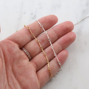 Puede incluir: Tres cadenas de diferentes longitudes, una dorada, una plateada y una plateada con textura de cuentas. Las cadenas est&aacute;n hechas de peque&ntilde;os eslabones rectangulares.