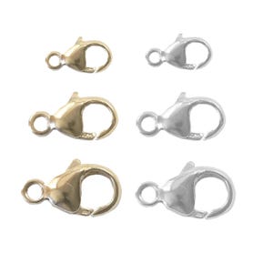 May include: Six metal lobster claw clasps in gold and silver tones. The clasps are designed for jewelry making, with a spring-loaded mechanism for secure closure. Each clasp has a small loop for attaching to a chain or other jewelry component.