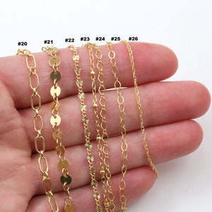 Peut inclure: Plusieurs colliers cha&icirc;ne dor&eacute;s de diff&eacute;rents styles, dont des maillons ovales, des disques et des cha&icirc;nes d&eacute;licates. Les colliers sont pr&eacute;sent&eacute;s sur un fond blanc, mettant en valeur leurs diff&eacute;rentes textures et motifs. Chaque cha&icirc;ne est num&eacute;rot&eacute;e.