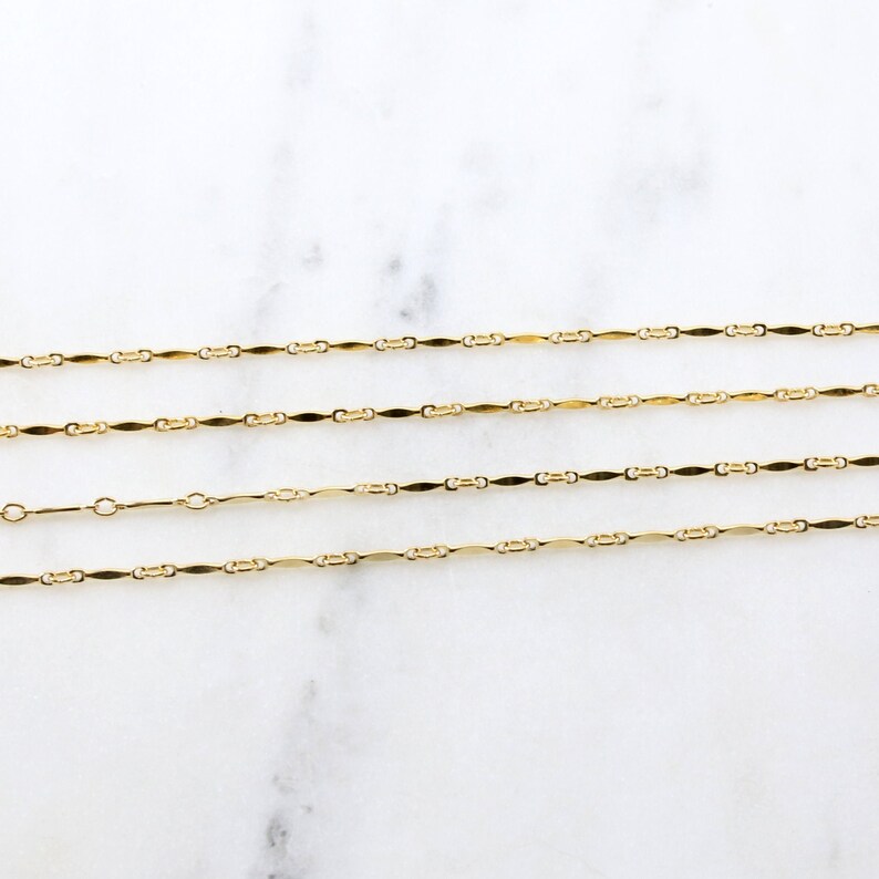 May include: Four gold chains of varying lengths, each with a delicate, flat, oval-shaped link design.