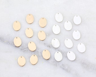 May include: A collection of 18 round metal charms, 9 gold and 9 silver, with a hole at the top for attaching to jewelry or other crafts.
