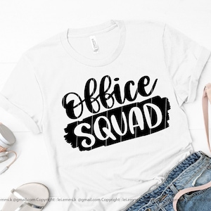 Może przedstawiać: Biała koszulka z czarnym napisem "Office Squad" w stylu pędzla.