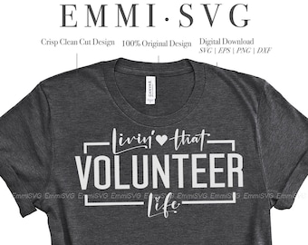 May include: A gray t-shirt with the text "Livin' that VOLUNTEER life" printed in white. The text is in a box with a heart symbol in the middle of the text. The t-shirt is on a white background.