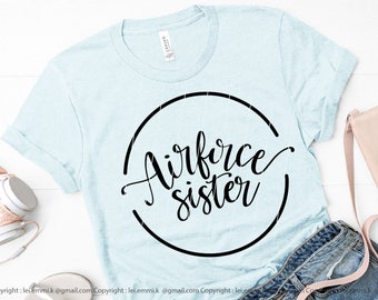 May include: A light blue t-shirt with a black circle graphic that says "Airforce Sister" in a cursive font.