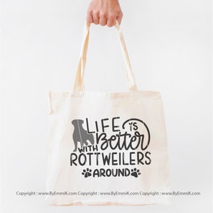 May include: A white canvas tote bag with a black silhouette of a Rottweiler and the text "Life is better with Rottweilers around".