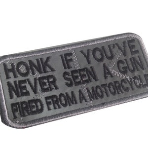 Pode incluir: Etiqueta bordada cinza com o texto "Honk if you've never seen a gun fired from a motorcycle."